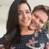 Abraçada ao marido, Michel Teló, Thais Fersoza usa vestido estampado que marca sua barriga de grávida